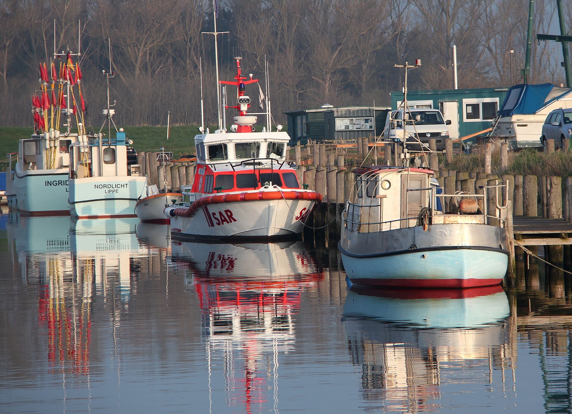Seenotrettungsboot der DGzRS liegt im Hafen zwischen Fischkuttern