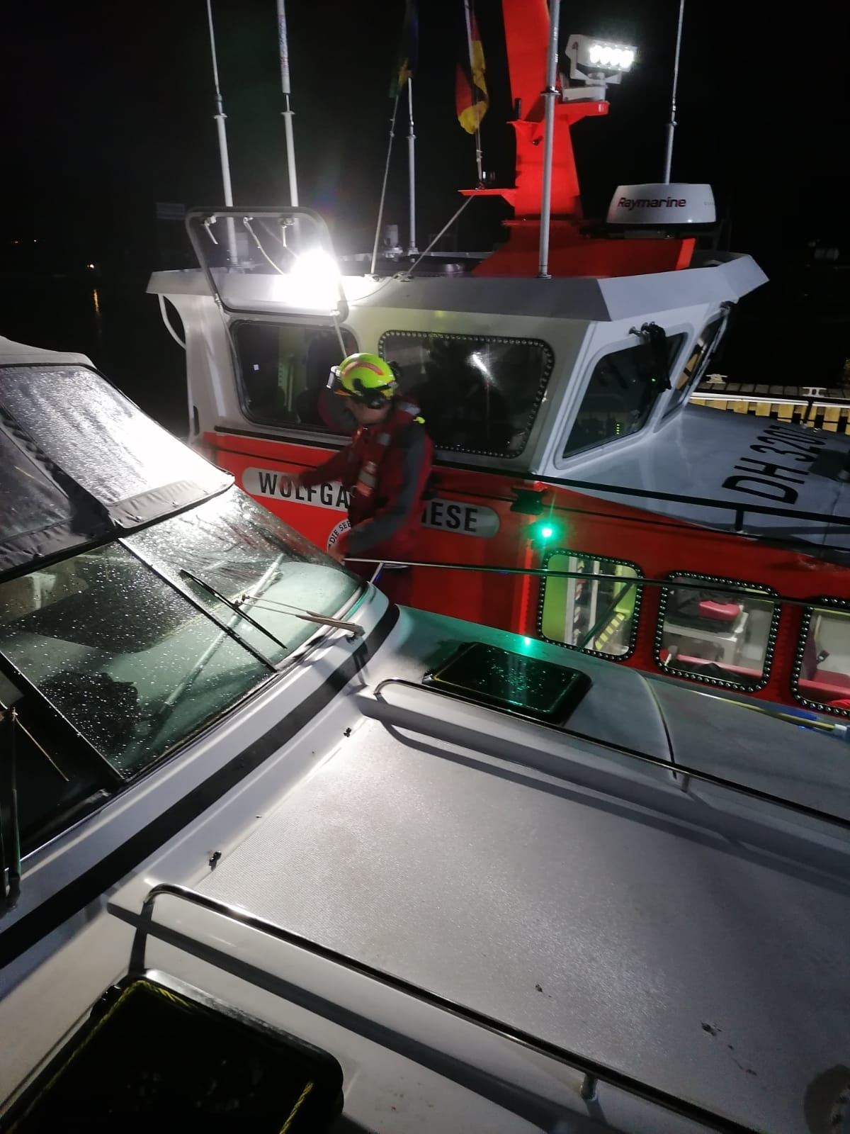 Seenotrettungskreuzer leuchtet einem Seenotretter den Weg während eines Einsatzes aufgrund von Rauchentwicklung in Boltenhagen