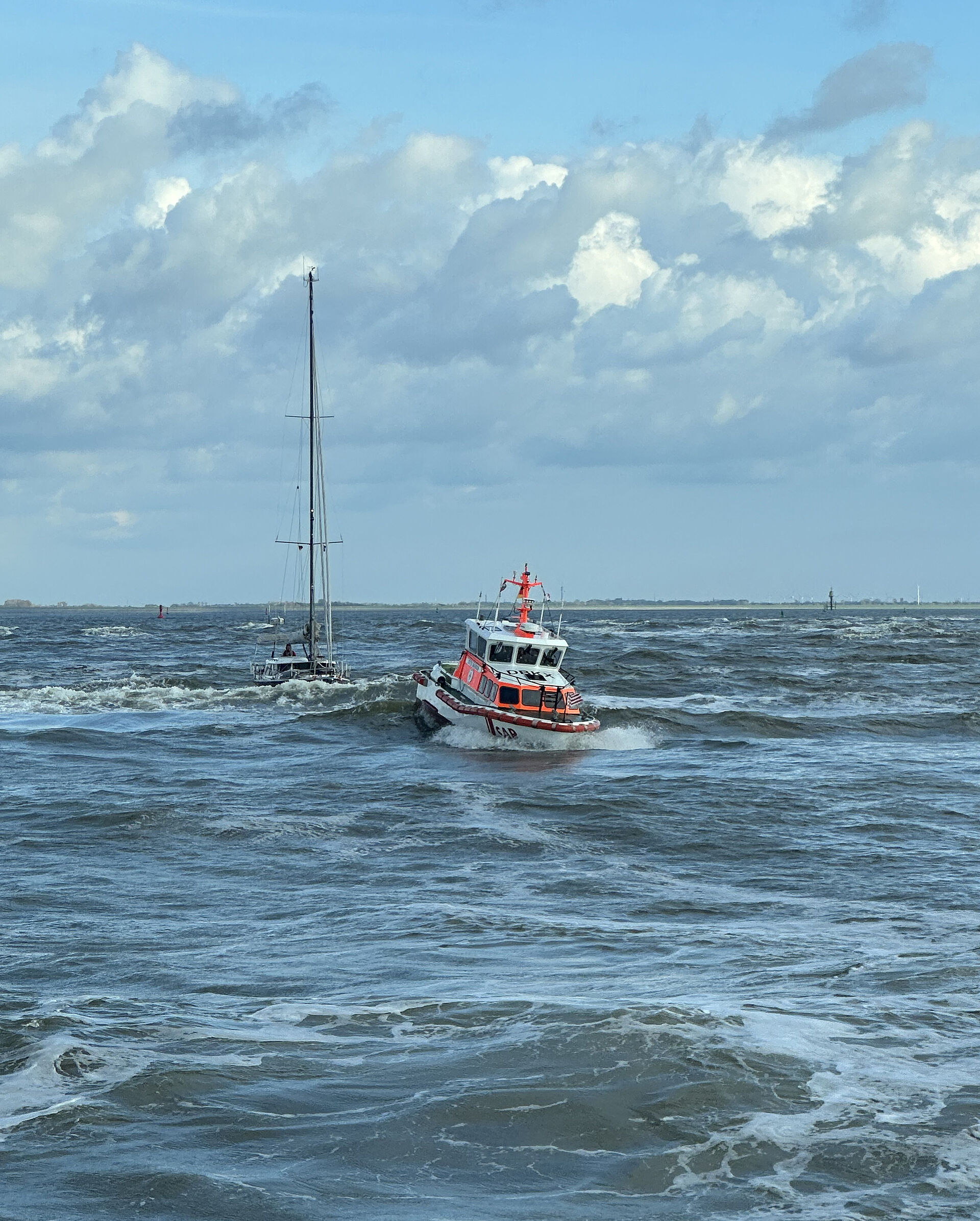 Seenotrettungsboot mit Segelyacht im Schlepp