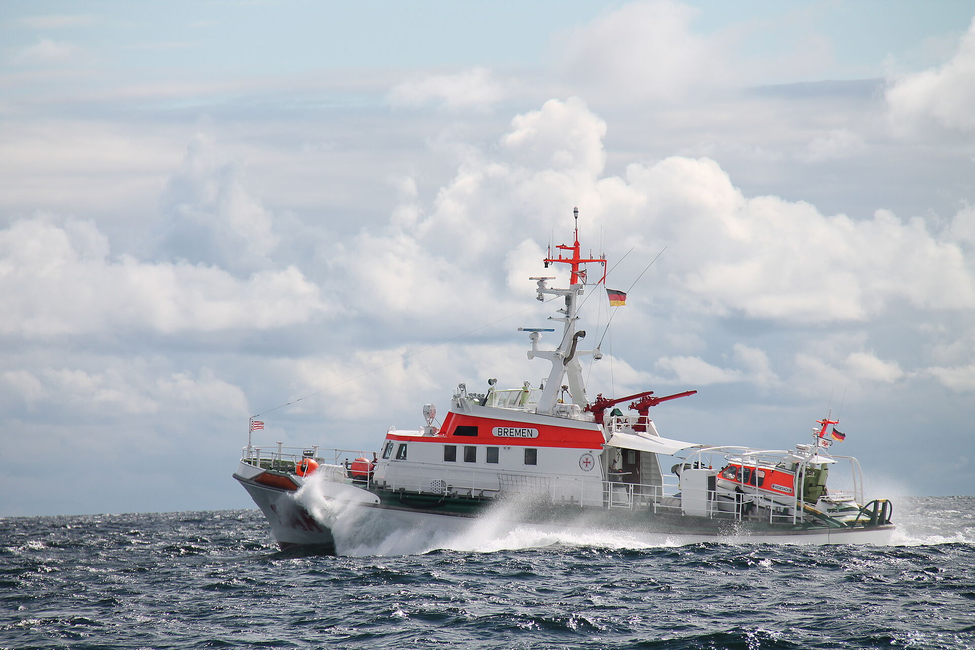 Seenotretter und Hubschrauber-Besatzung im Einsatz für medizinischen Notfall an Bord einer Segelyacht