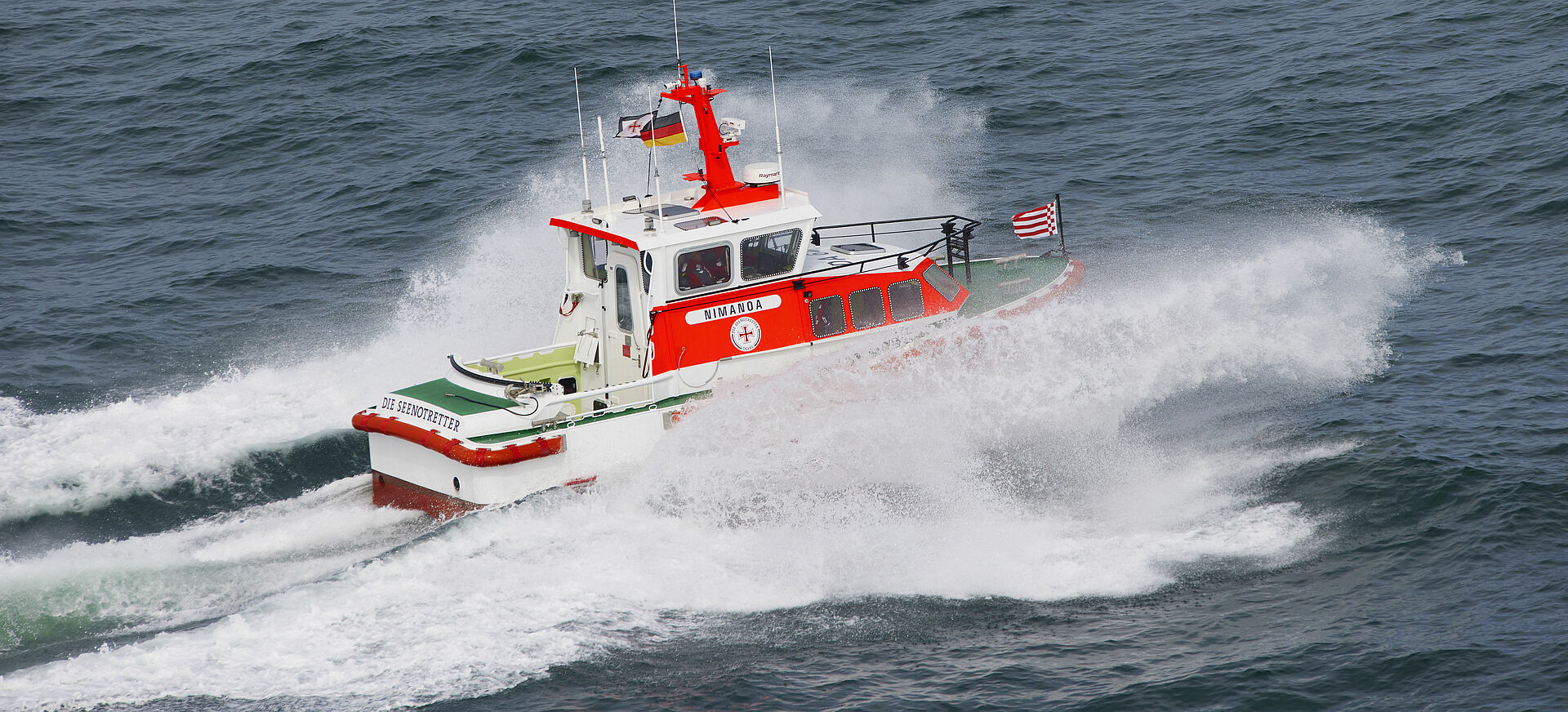 Das Seenotrettungsboot NIMANOA fährt in schneller Geschwindigkeit durch die flache Ostsee.