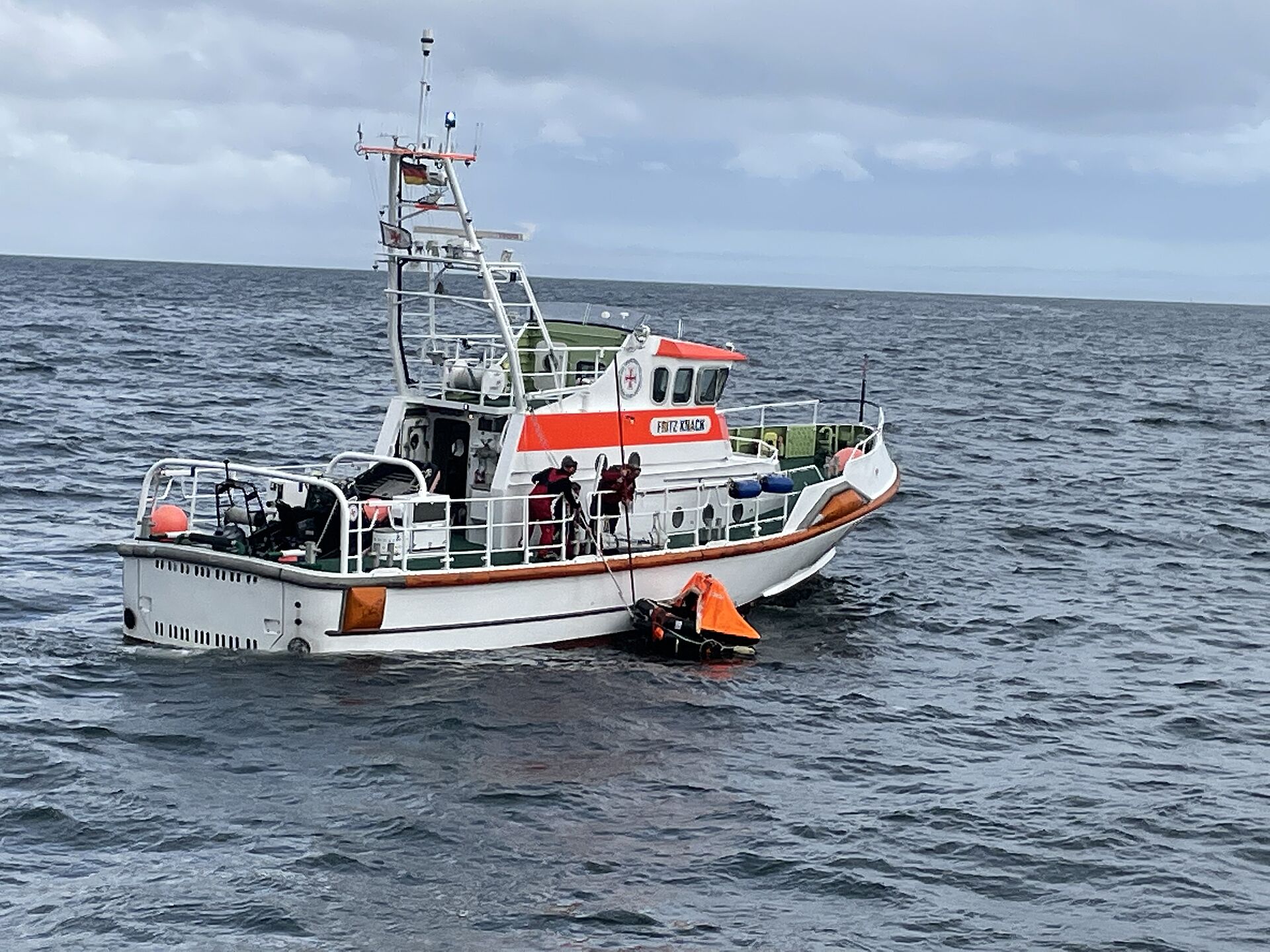 Seenotrettungskreuzer nimmt Rettungsinsel auf