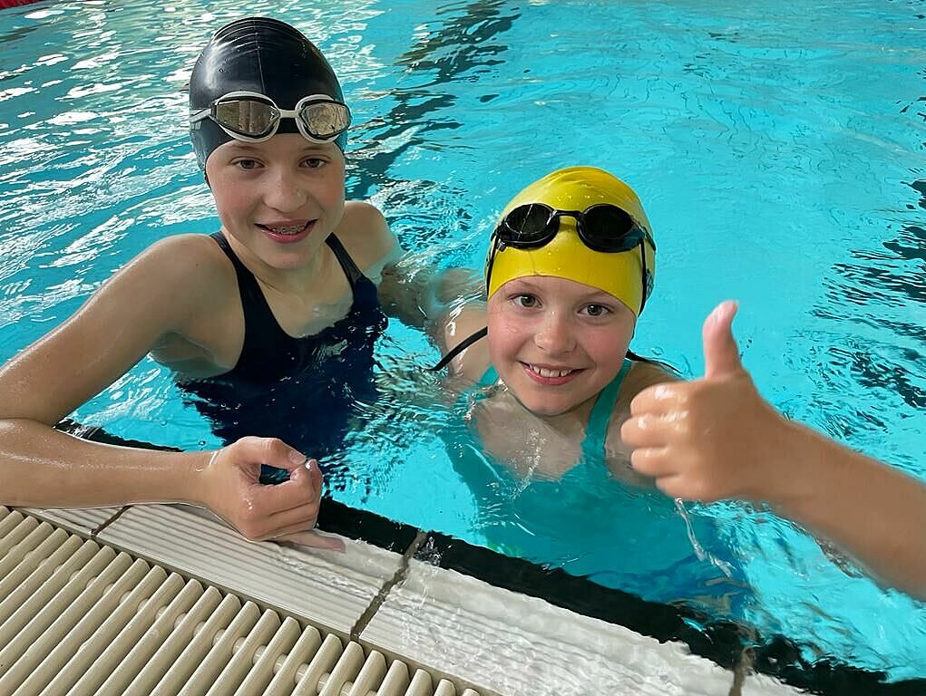 Die Schülerinnen Teresa (l.) und Sofia Krabbe im Wasser eines Schwimmbades, wo sie Spenden für die Seenotretter erschwommen haben.