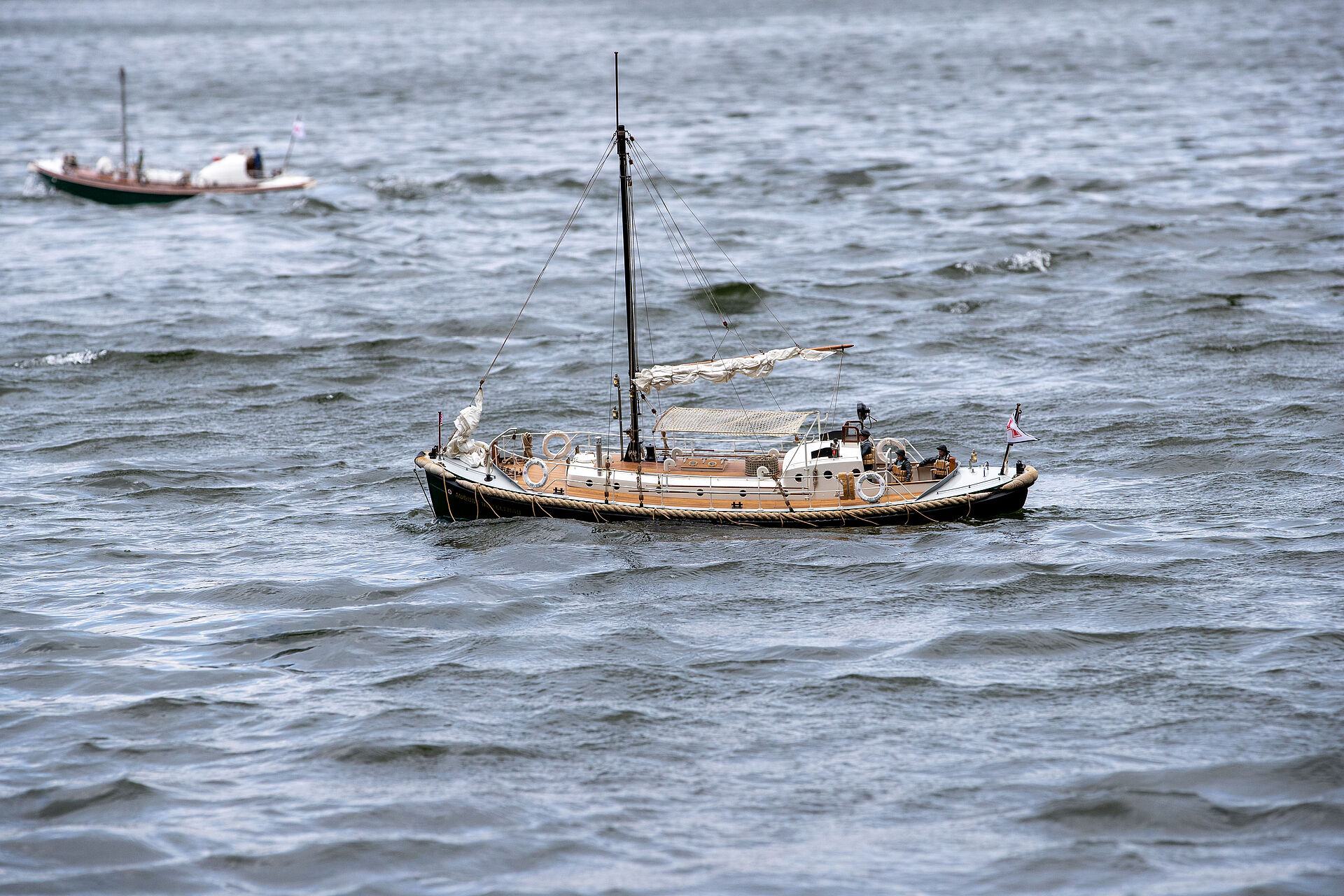 Ein Modell eines historischen Motorrettungsbootes der DGzRS fährt im Wasser.