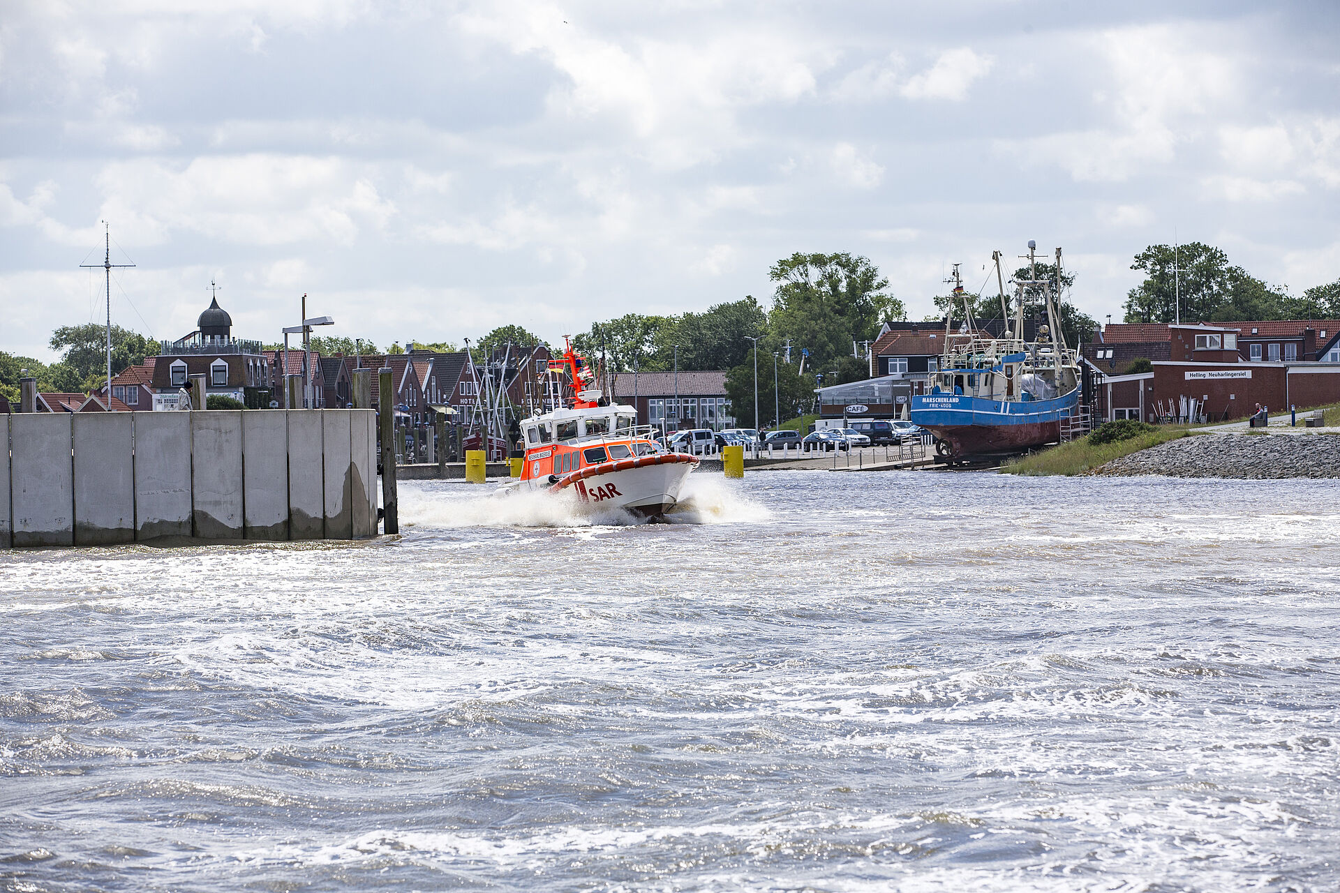 Das Seenotrettungsboot NEUHARLINGERSIEL der DGzRS verlässt den Hafen des gleichnamigen Küstenortes.