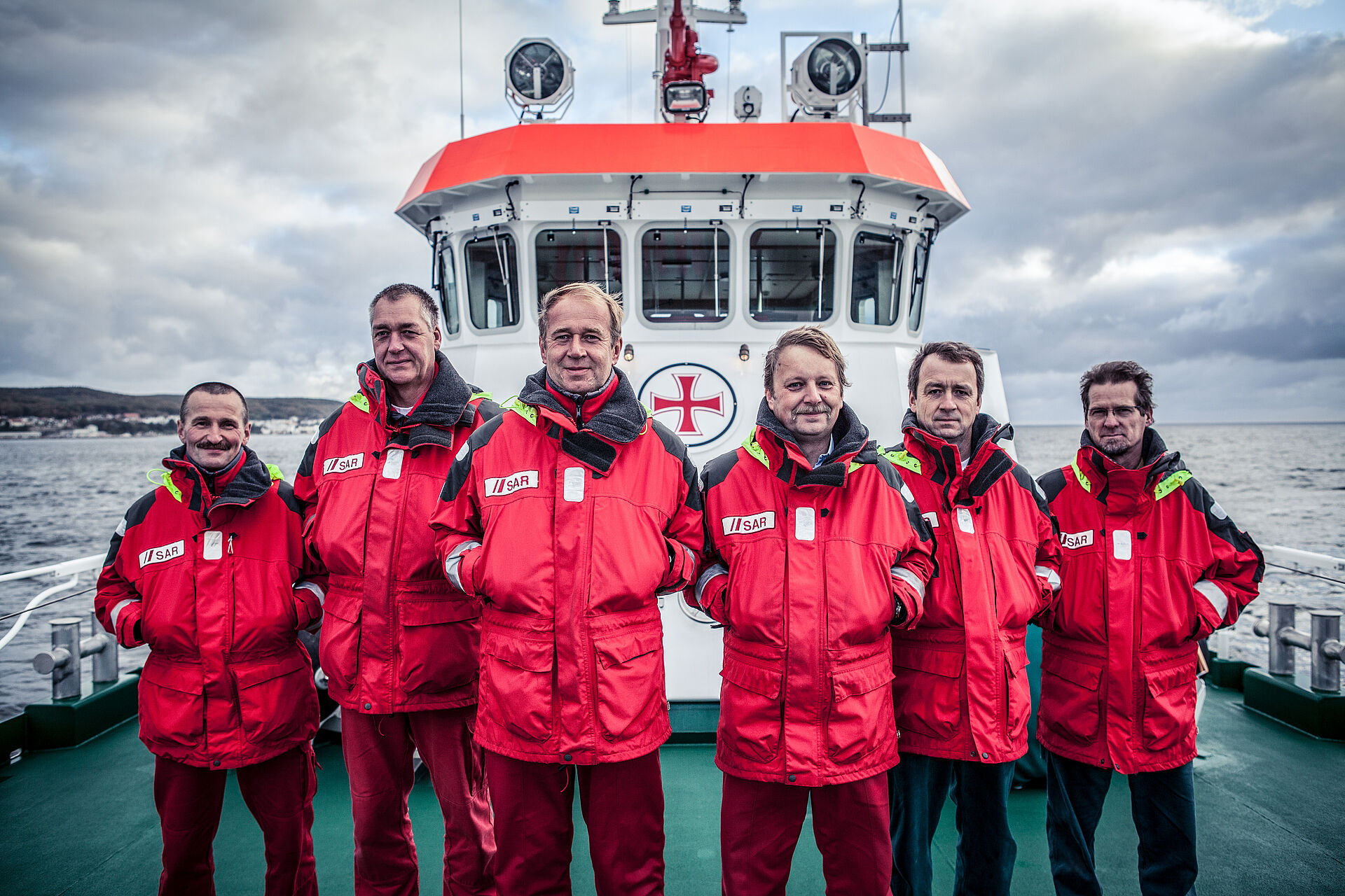 Seenotretter-Crew versammelt an Deck ihres Seenotrettungskreuzers