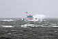 Ein rot-weißer Seenotrettungskreuzer kämpft sich durch die stürmische Nordsee.