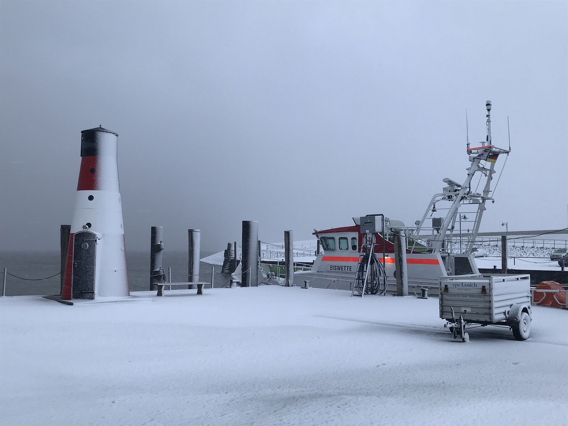 Seenotrettungskreuzer im zugeschneiten Hafen 
