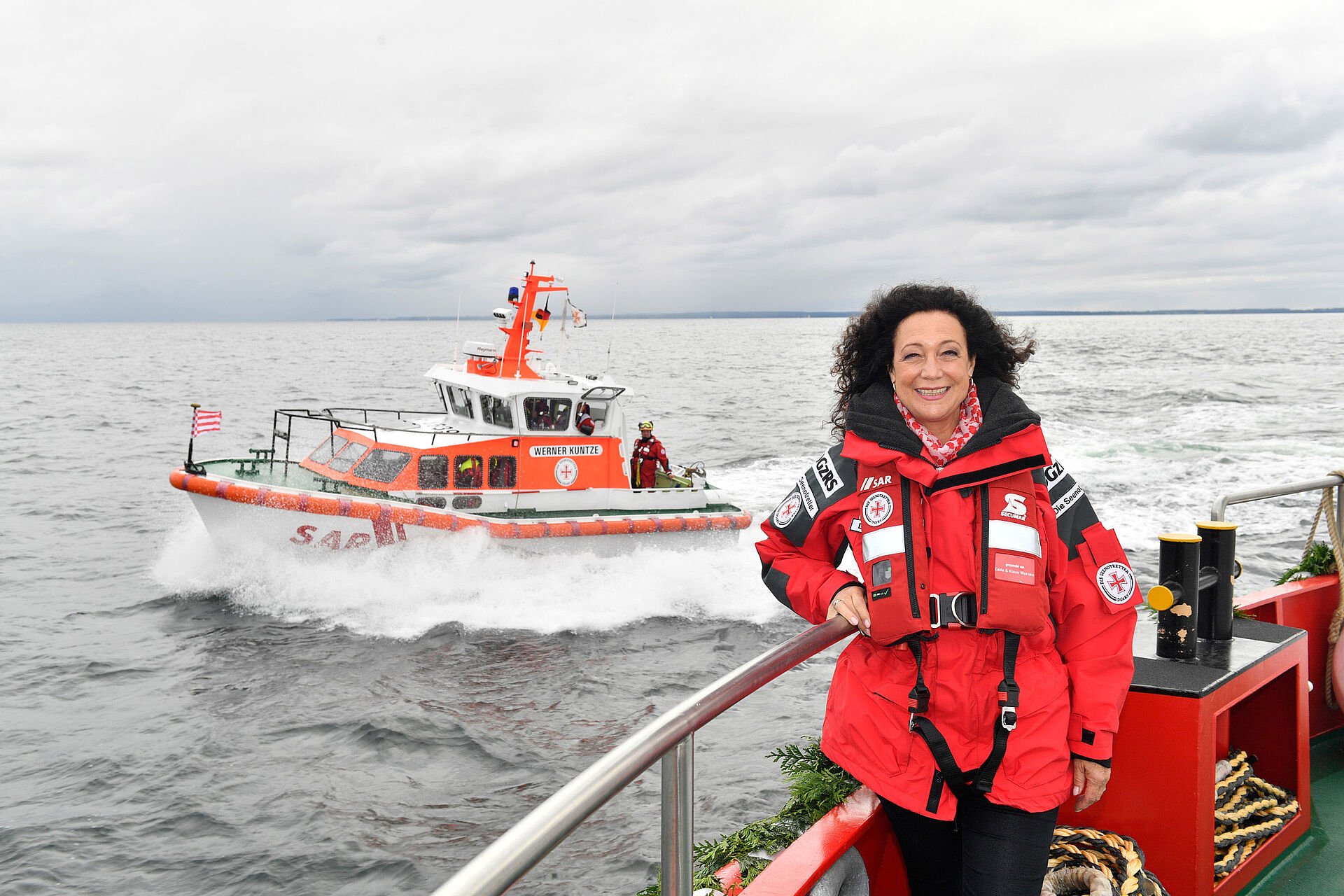 Barbara Wussow vor einem Seenotrettungsboot in Fahrt