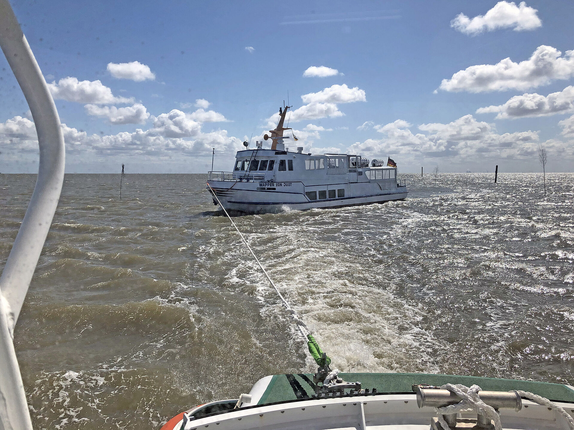 Ein Seenotrettungsboot ist per Leine mit einem Fahrgastschiff verbunden.