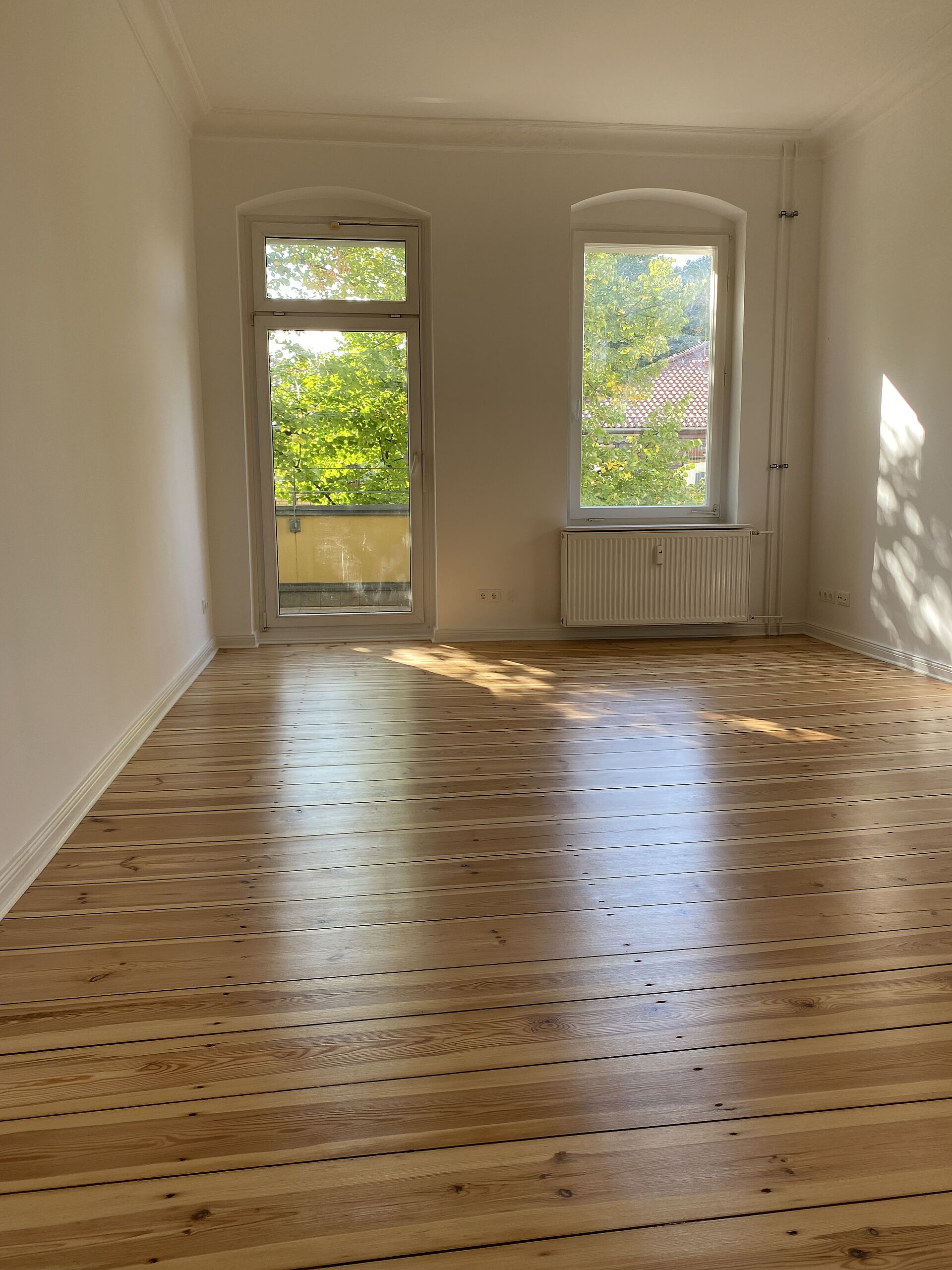 Blick in ein renoviertes Zimmer mit geschliffenem Parkettboden