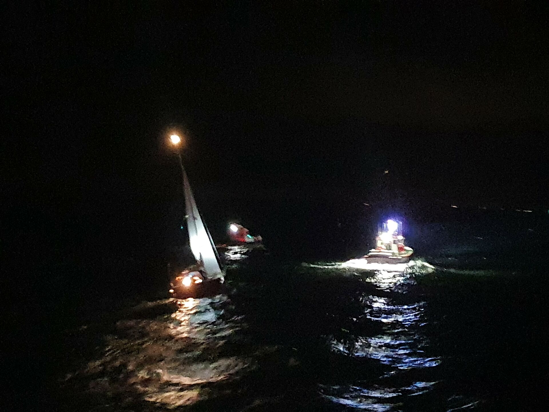 Seenotretter helfen einer Yacht nach Wassereinbruch auf hoher See in der Nacht