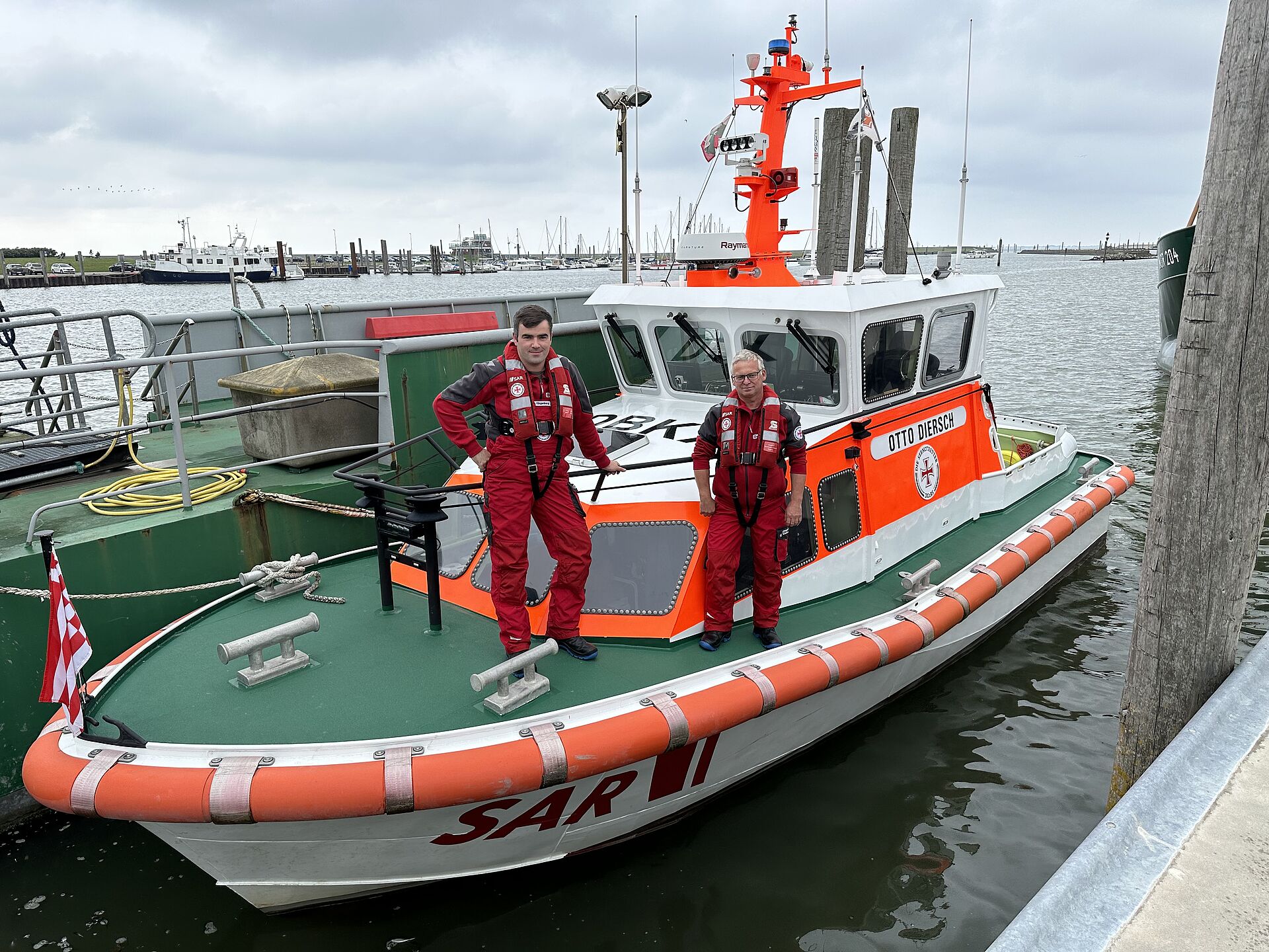 Der neue Vormann der Freiwilligen-Station Norddeich, Alexander Klingenborg (l.) und sein Vorgänger Marcus Baar, bekleidet mit rotem Überlebensanzug, an Bord des DGzRS-Seenotrettungsbootes OTTO DIERSCH.