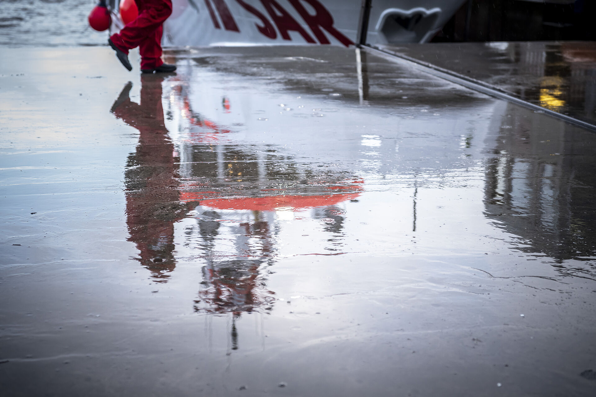 Spiegelung des Seenotrettungskreuzers im nassen Boden des Hamburger Stapelhubs
