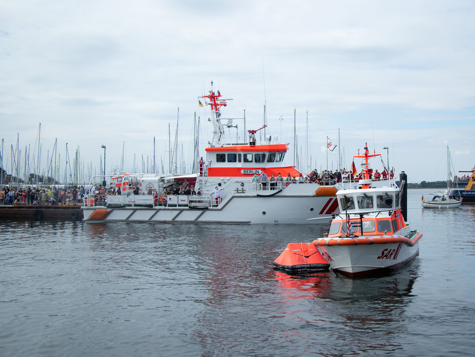 Rettungsinsel und zwei Rettungsschiffe der Seenotretter im Hafenbecken