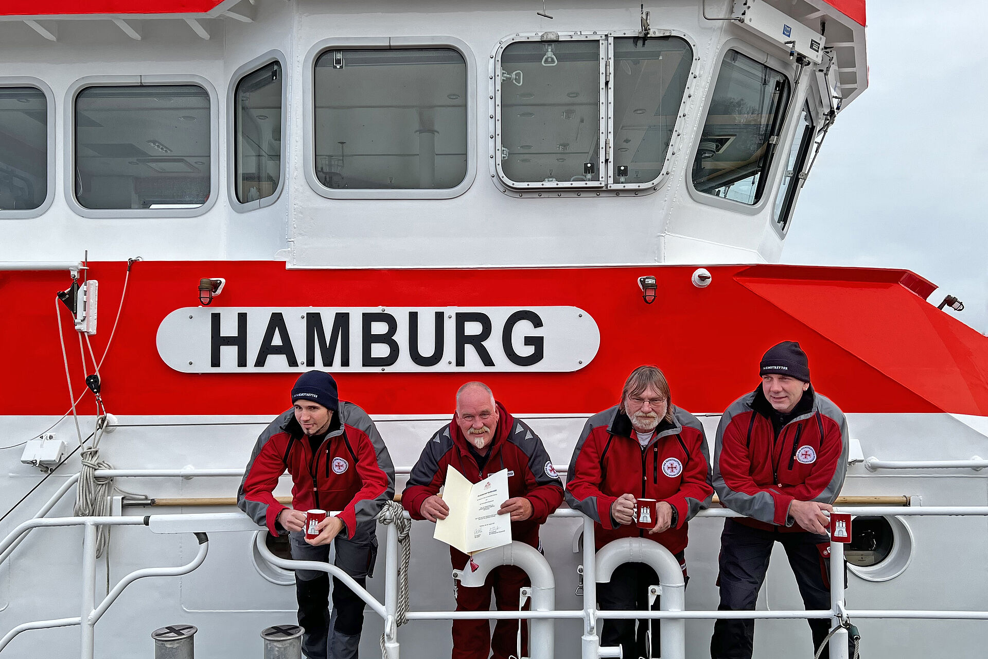 Seenotretter an Bord zeigen Patenschafts-Urkunde