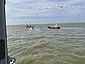 Zwei Seenotrettungsboote auf der Nordsee nähern sich einem Fischkutter.