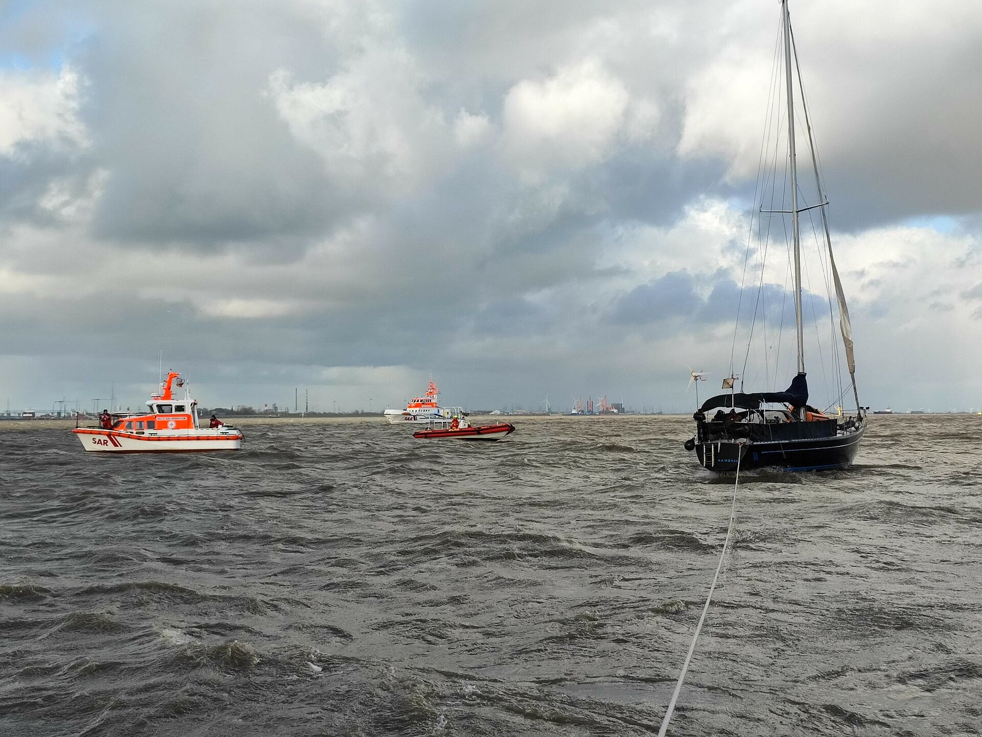 Eine Yacht wird freigeschleppt. Im Bild sind 2 Rettungseinheiten der DGzRS und ein DLRG-Boot.