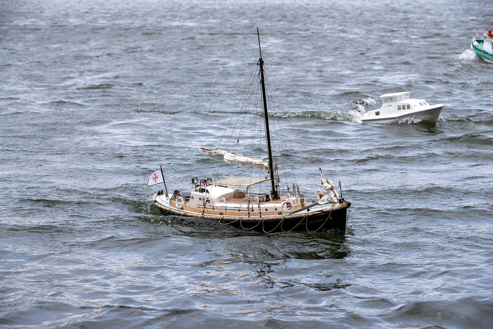 Ein Modell eines historischen Motorrettungsbootes der DGzRS fährt im Wasser.