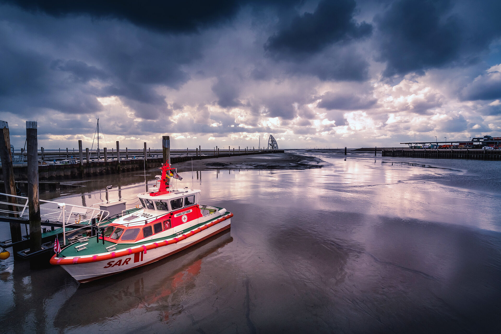 Im Sonnenuntergang liegt das Seenotrettungsboot an seinem Anleger im Hafenbecken von Juist.