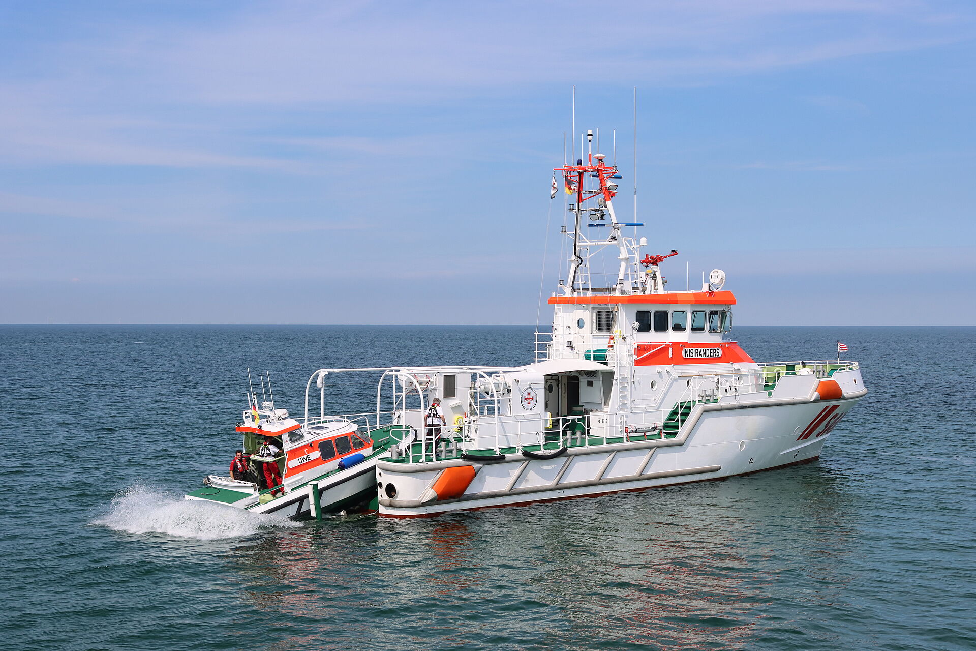 Ein Tochterboot wird von einem Seenotrettungskreuzer zu Wasser gelassen
