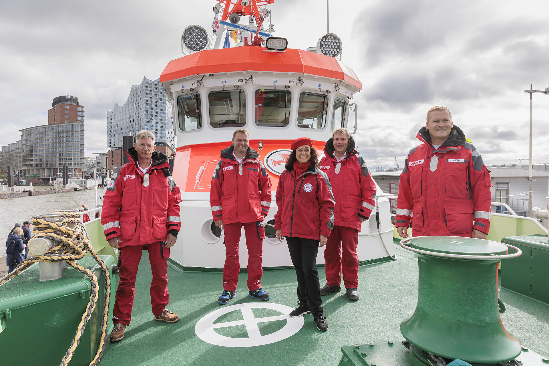 Vier Seenotretter und Schauspielerin Barbara Wussow stehen auf dem Vorschiff des Seenotrettungskreuzers HAMBURG.