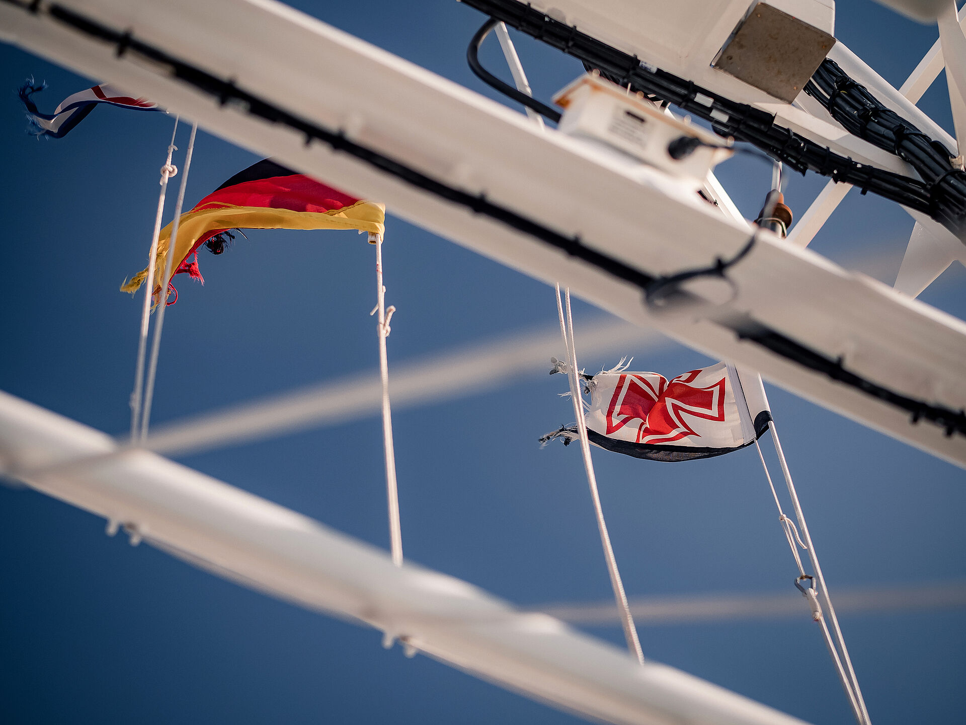 Seenotretterflagge und Deutschlandflagge wehen im Wind
