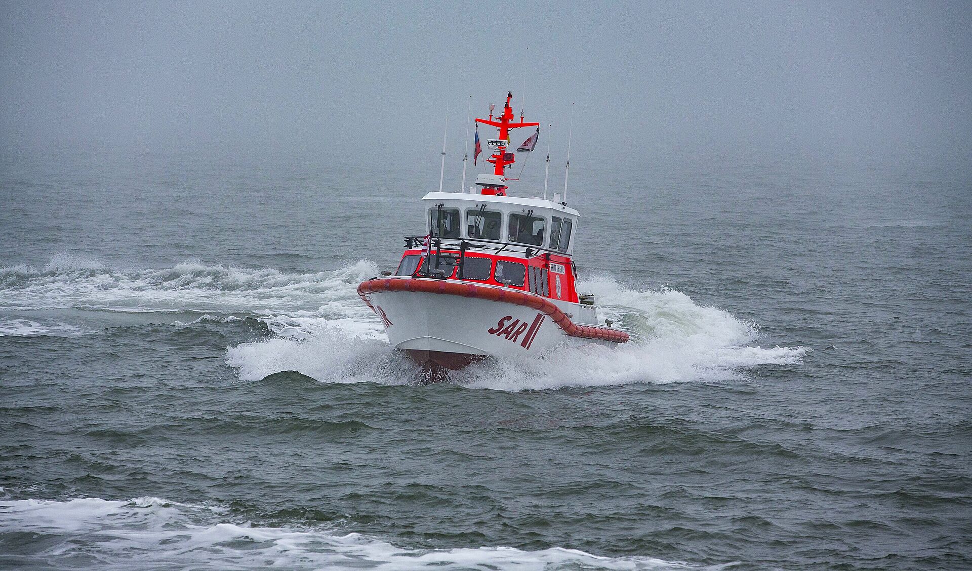Das Seenotrettungsboot FRITZ THIEME fährt durch die nebelige Nordsee vor Wangerooge.