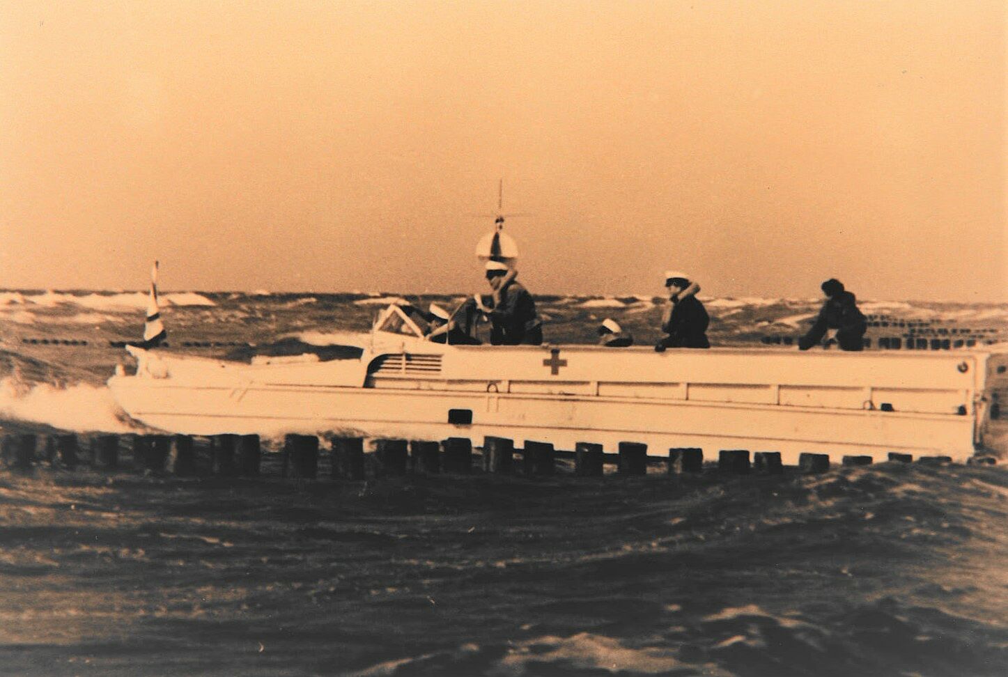 Ein altes Foto von drei Personen auf einem Schiff im Einssatz