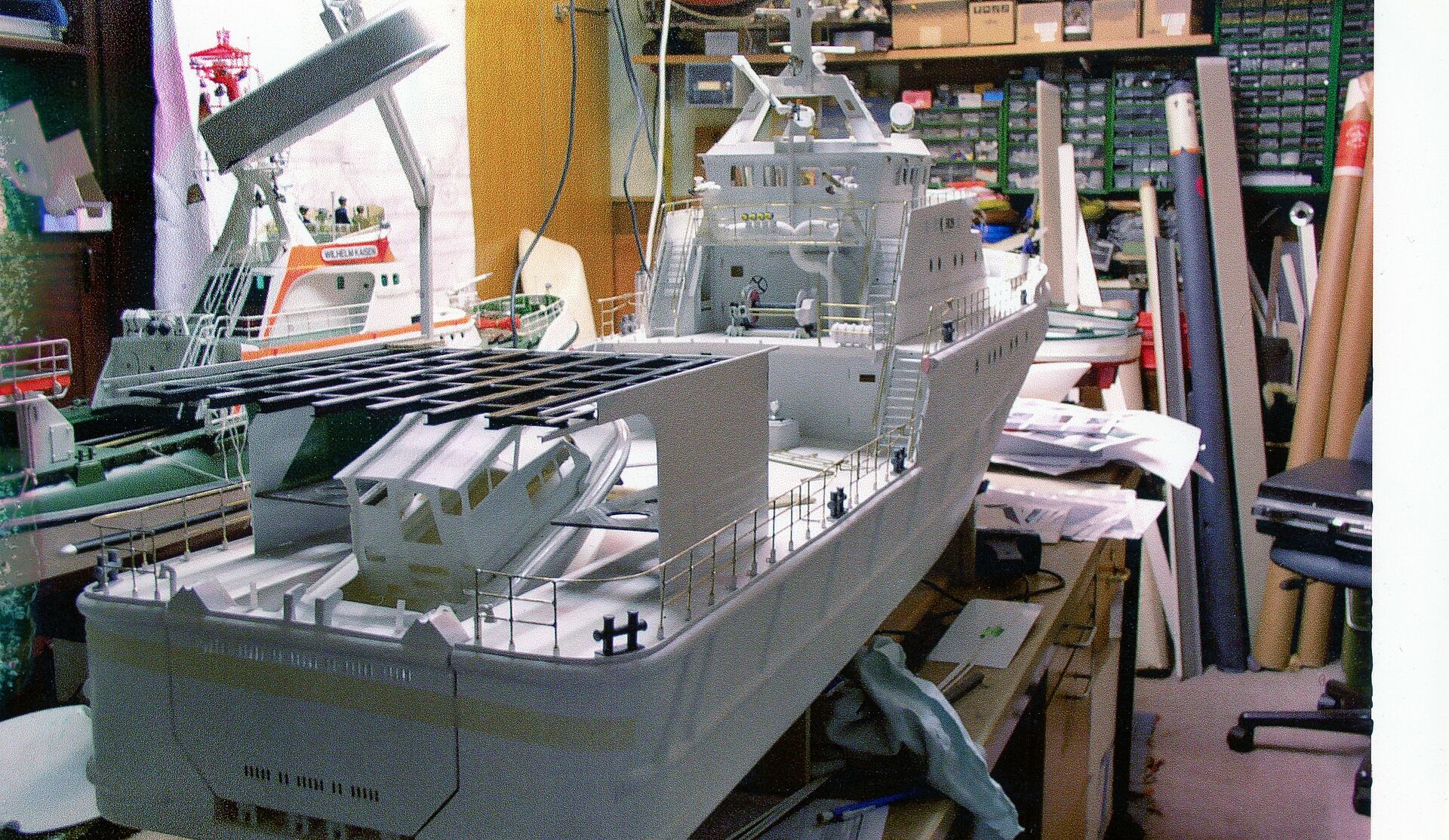 In einer Werkstatt steht ein Modell des größten Seenotrettungskreuzers der DGzRS, es ist noch grau.