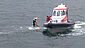 Zwei Schiffbrüchige werden von einem Seenotrettungsboot gerettet