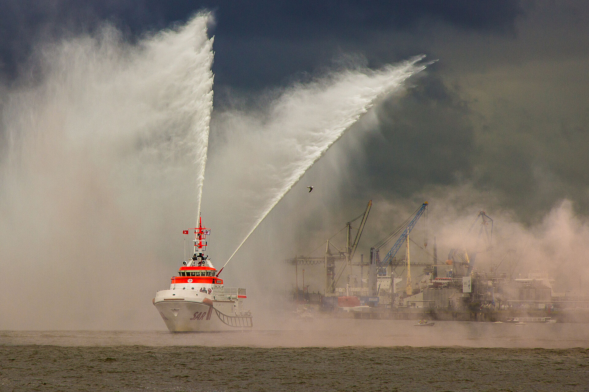 Seenotrettungskreuzer löscht brennendes Schiff auf hoher See