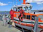 Vormann Bernd Abels (r.) und sein Vorgänger Roger Riehl in roter Dienstkleidung auf dem Seenotrettungsboot FRITZ THIEME.