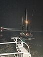 Der Seenotrettungskreuzer HAMBURG hat in der Dunkelheit eine Segelyacht im Schlepp, im Hintergrund das Tochterboot ST. PAULI 