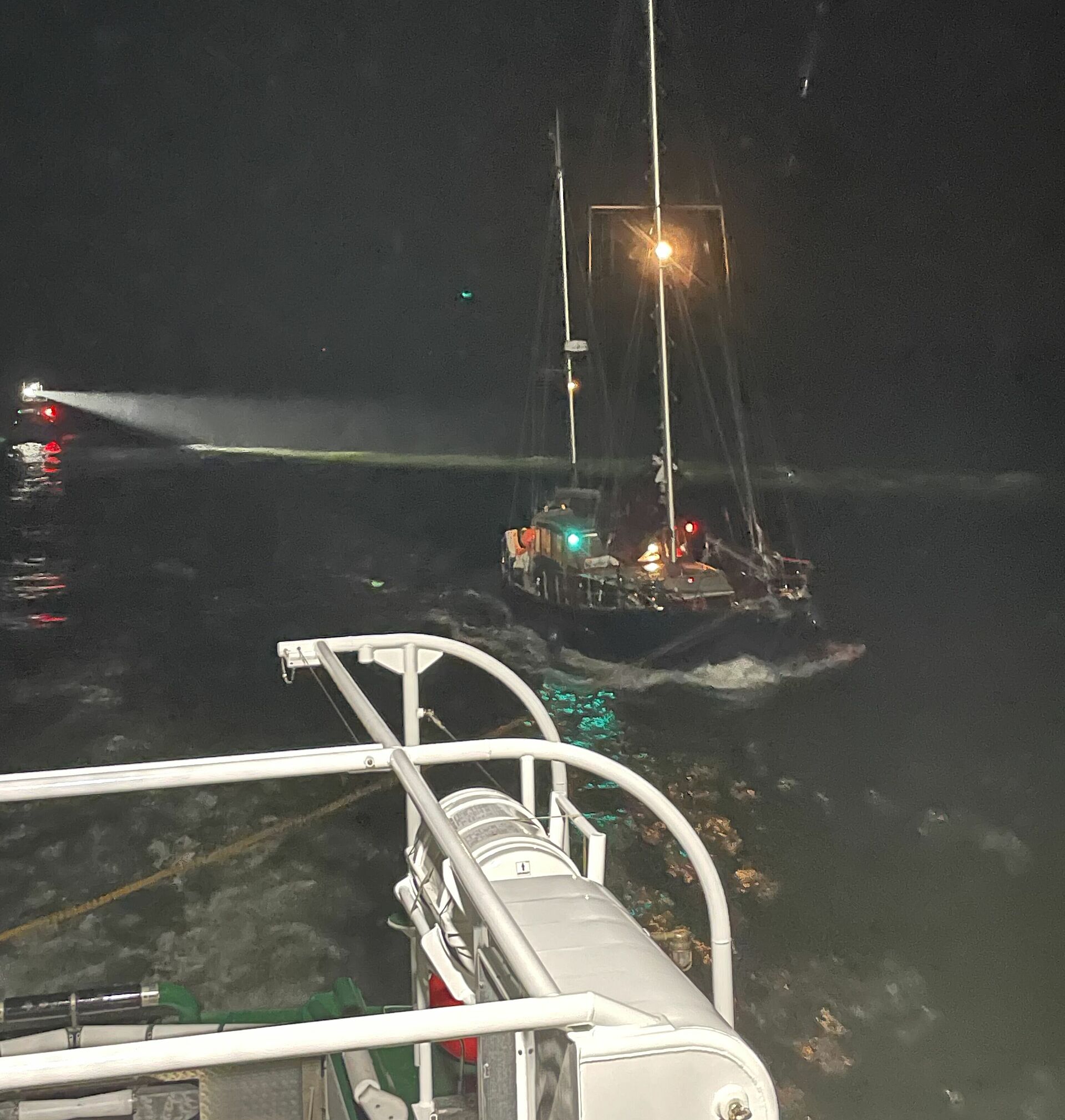 Der Seenotrettungskreuzer HAMBURG hat in der Dunkelheit eine Segelyacht im Schlepp, im Hintergrund das Tochterboot ST. PAULI 