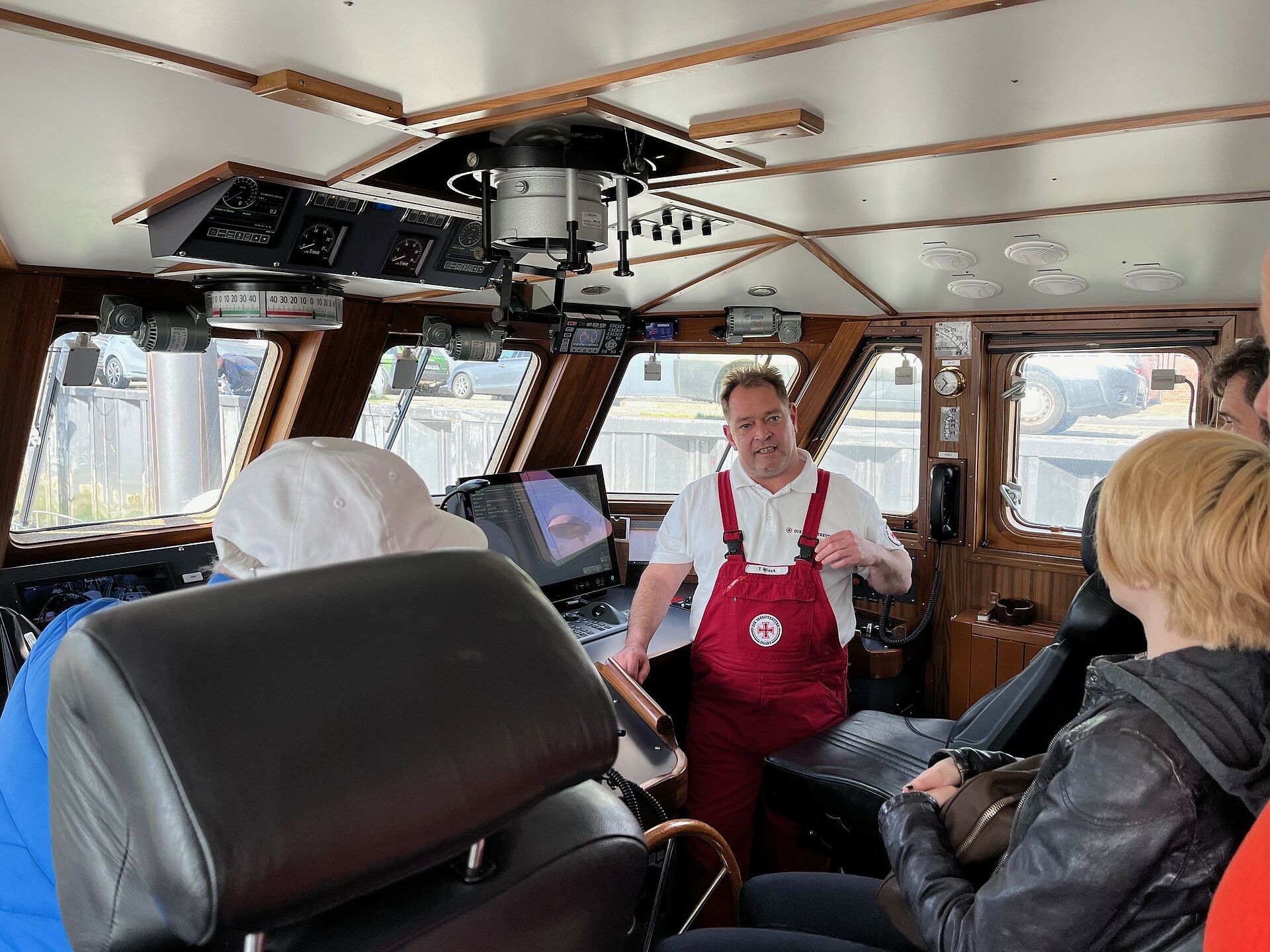 Seenotretter-Vormann erläutert den Besuchern des Seenotrettungskreuzers die Navigations- und Kommunikationsgeräte auf der Brücke der HERMANN RUDOLF MEYER.