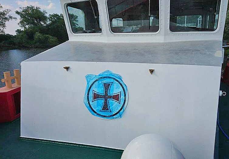 Seenotretter-Logo mit frischer Folie bedeckt vorne an dem Bootshaus