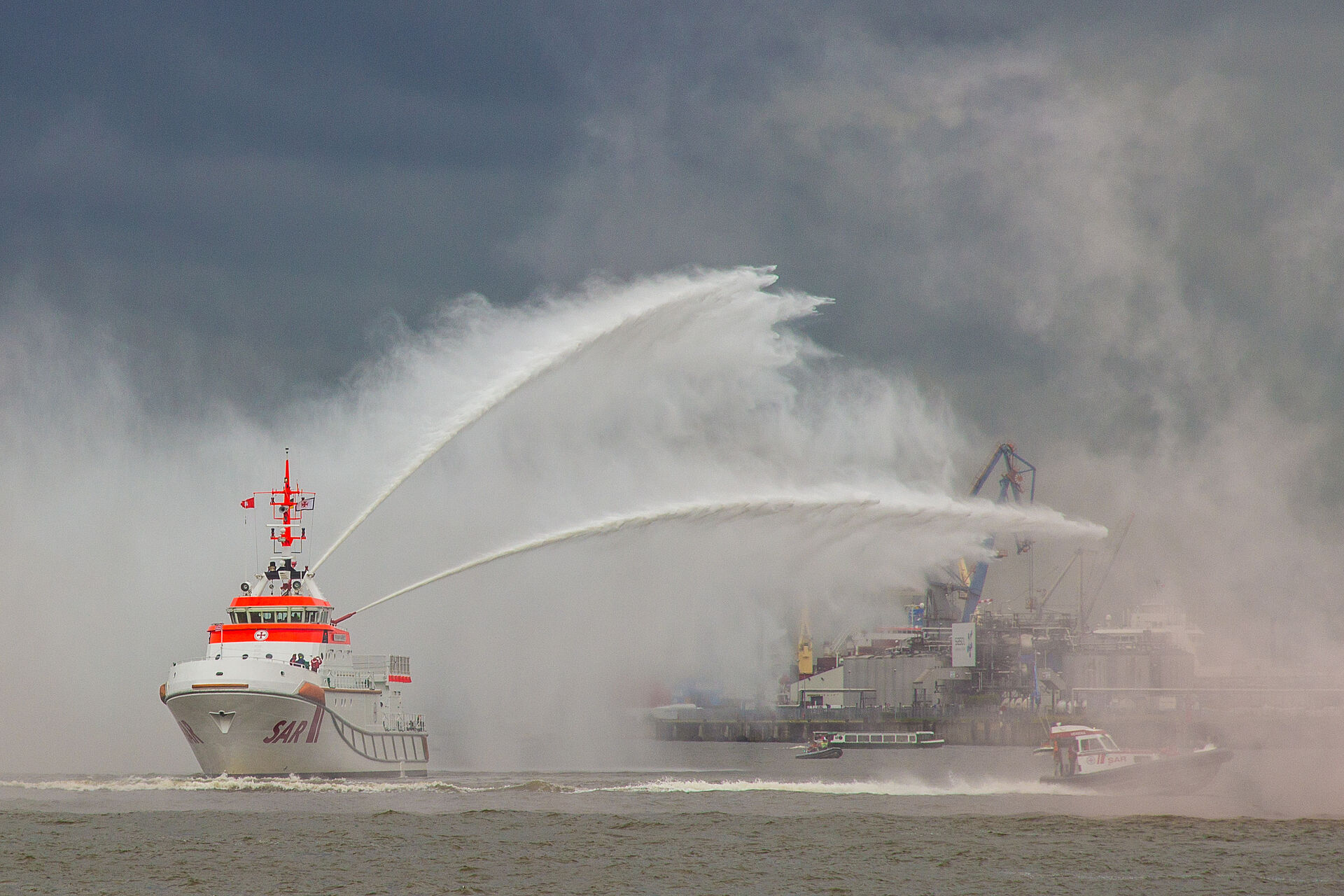 Seenotrettungskreuzer löscht brennendes Schiff auf hoher See