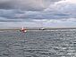 Das Tochterboot eines Seenotrettungskreuzers nahe einem gestrandeten Trimaran in der Nordsee