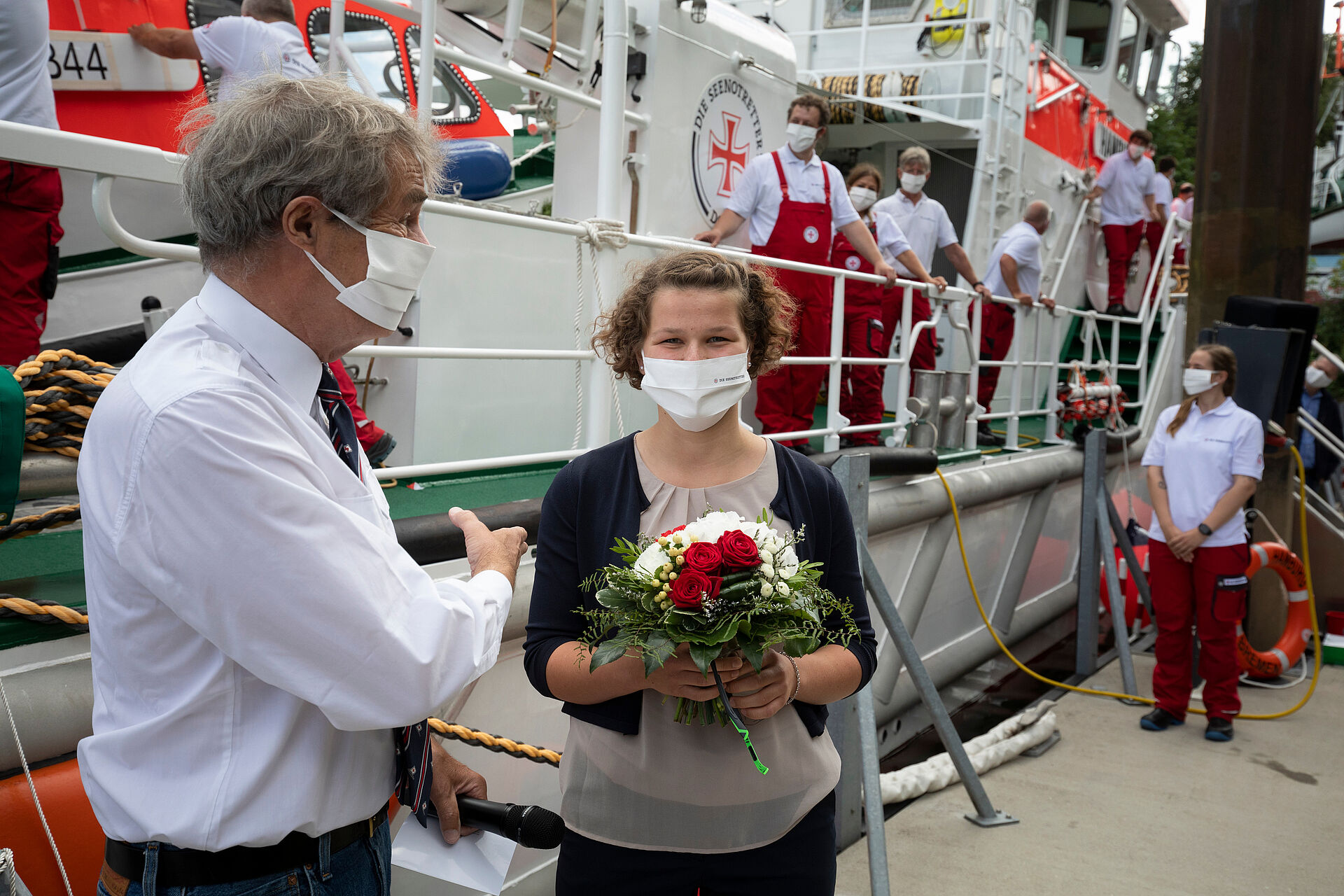 Frau bekommt einen Blumenstrauß von den Seenotrettern