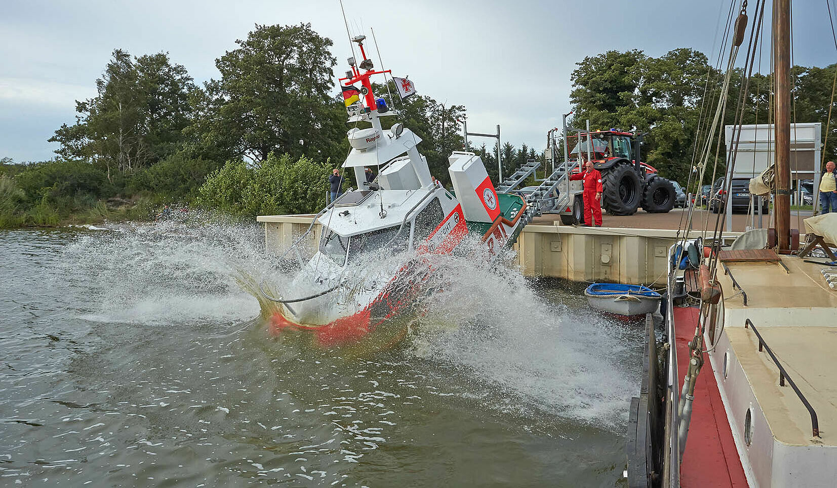 Im Hafen am Achterwasser von Zinnowitz gleitet das Seenotrettungsboot HECHT vom Trailer von der Hafenmauer in das Hafenbecken.