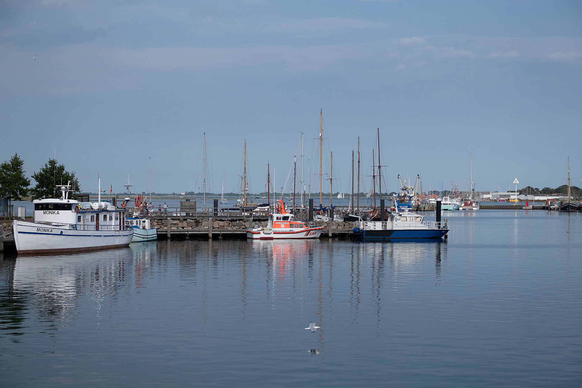 Das Seenotrettungsboot liegt bei sonnigem Wetter im Hafen von Heiligenhafen.