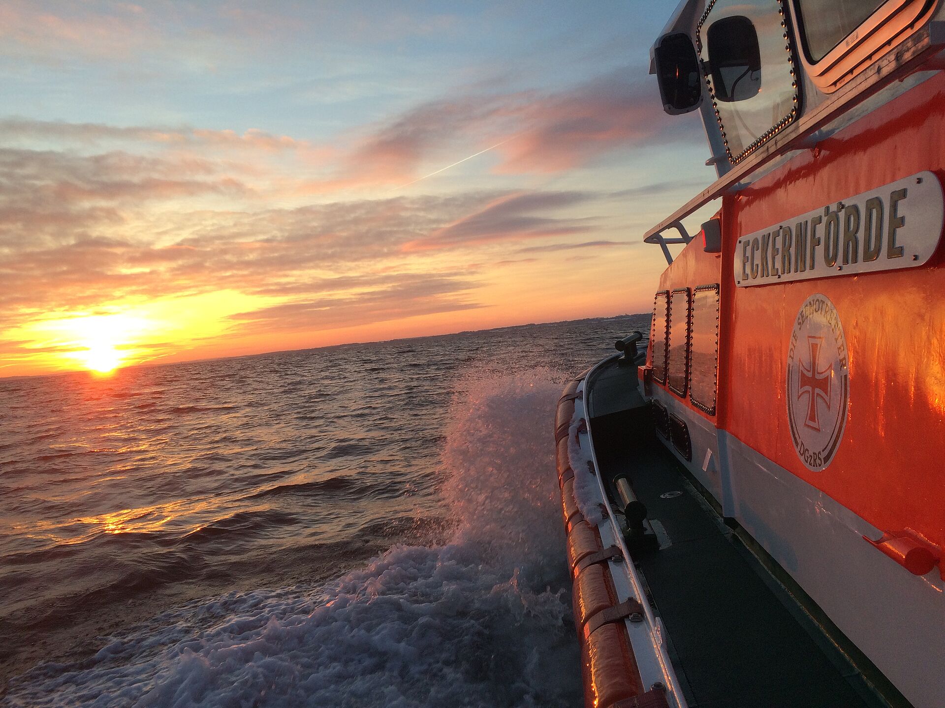 Seenotrettungsboot Eckernförde fährt auf den Sonnenuntergang zu.