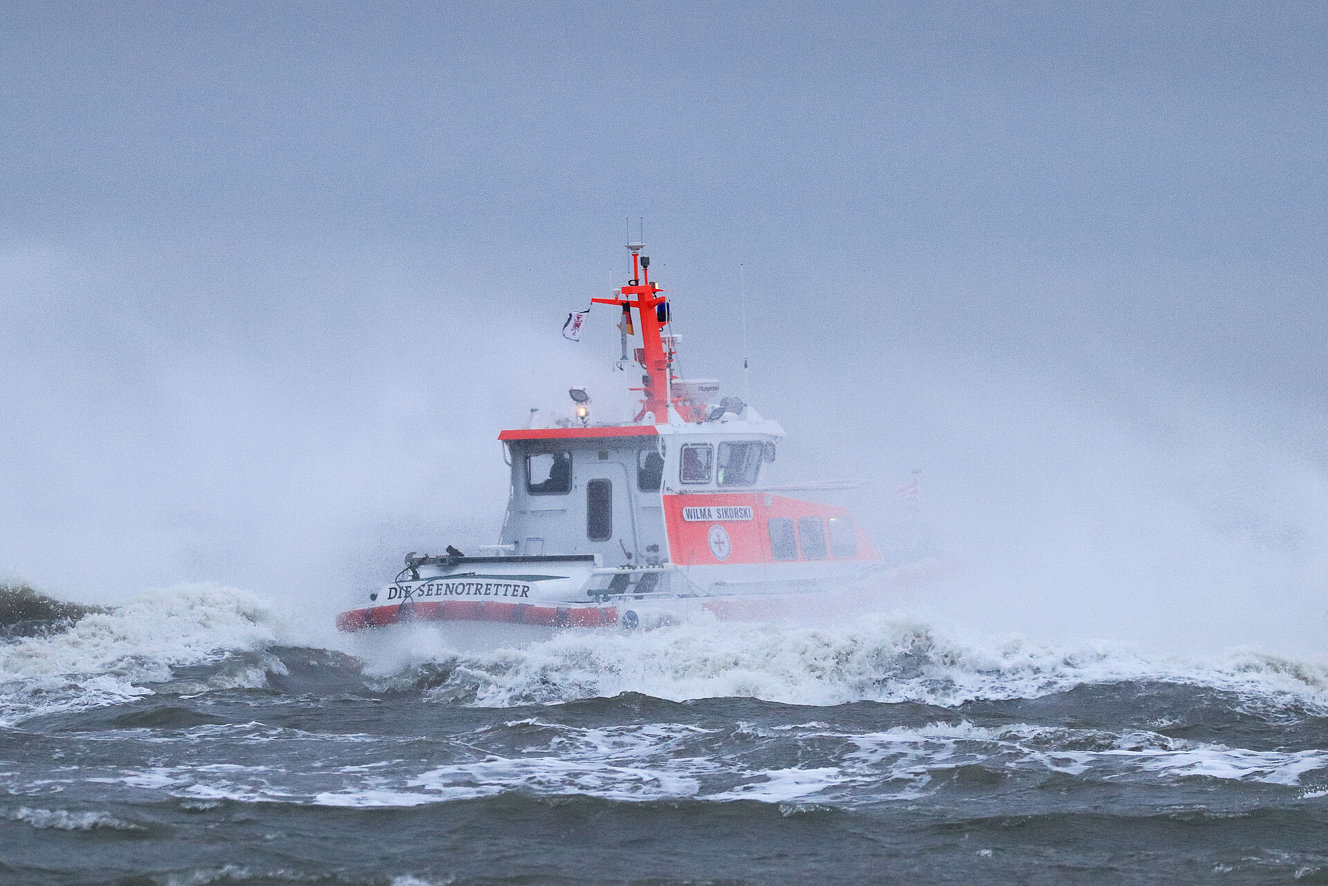 An einem nebeligen Tag fährt das Seenotrettinungsboot WILMA SIKORSKI durch Wellen.