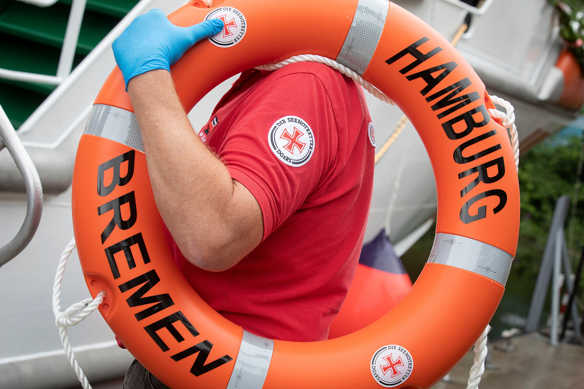 Mann trägt Rettungsring mit der Aufschrift HAMBURG BREMEN