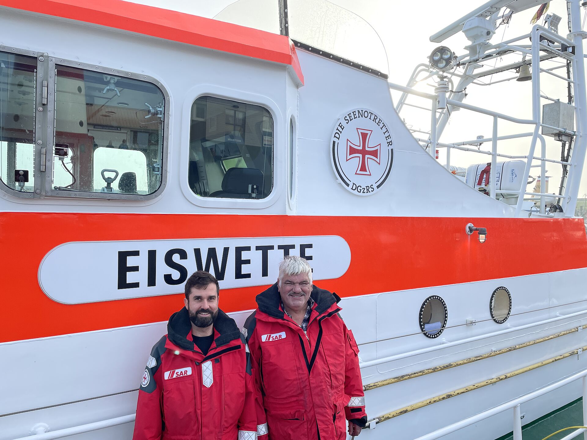 Neuer Vormann der DGzRS-Station Nordstrand, Chris Erbacher, und sein Vorgänger Ernst Dostal stehen vor dem Seenotrettungskreuzer EISWETTE 