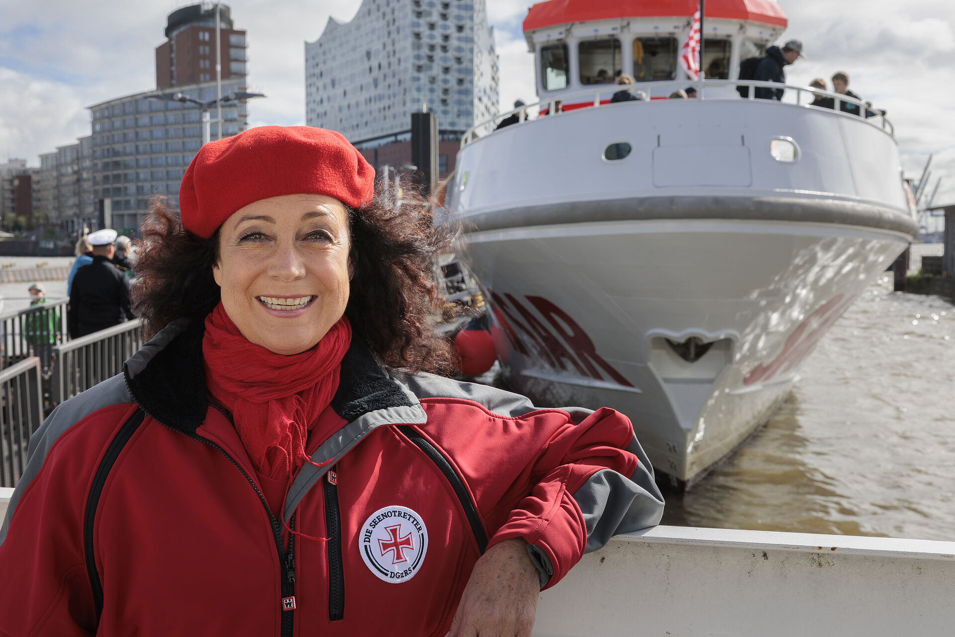Schauspielerin Barbara Wussow steht vor dem rot-weißen Seenotrettungskreuzer HAMBURG im Hamburger Hafen.
