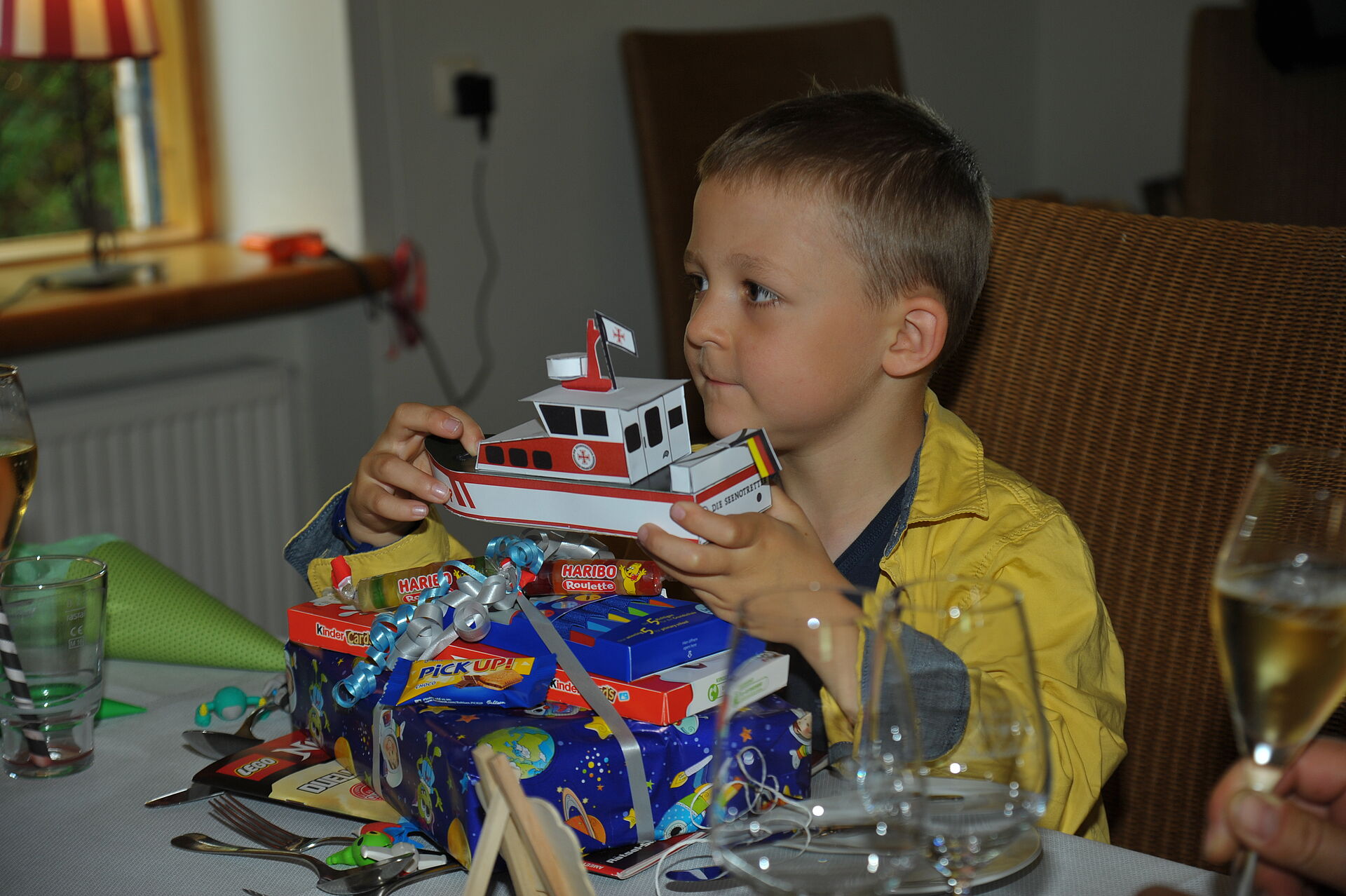 Junge hält selbst gebasteltes Sammelschiffen in den Händen