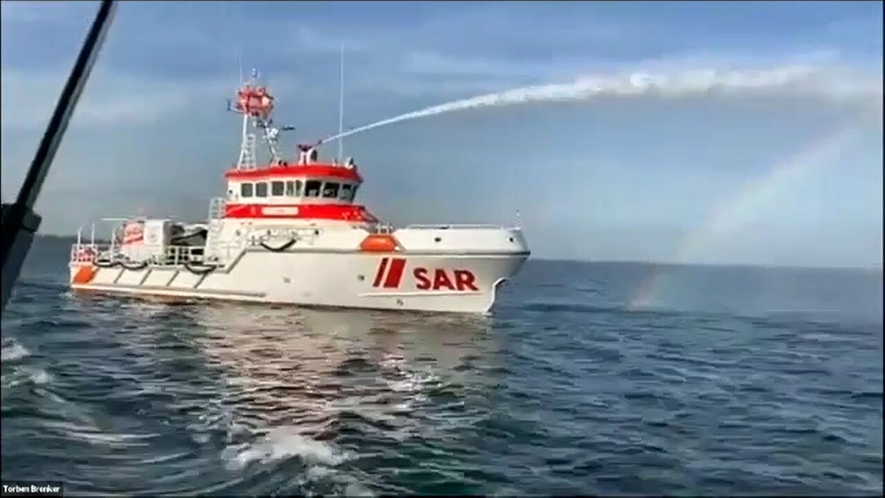 Seenotretterkreuzer auf hoher See mit Wasserwerfer im Einsatz