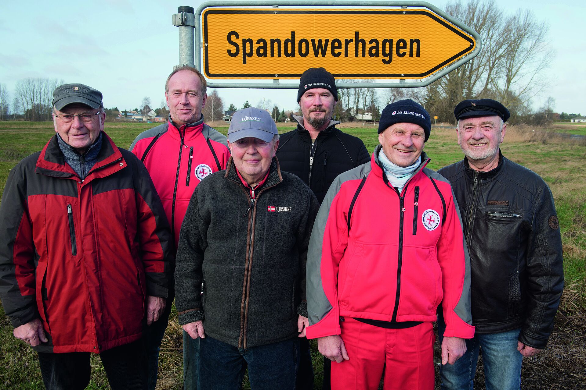6 Männer stehen vor einem Schild mit der Aufschrift "Spandowerhagen"